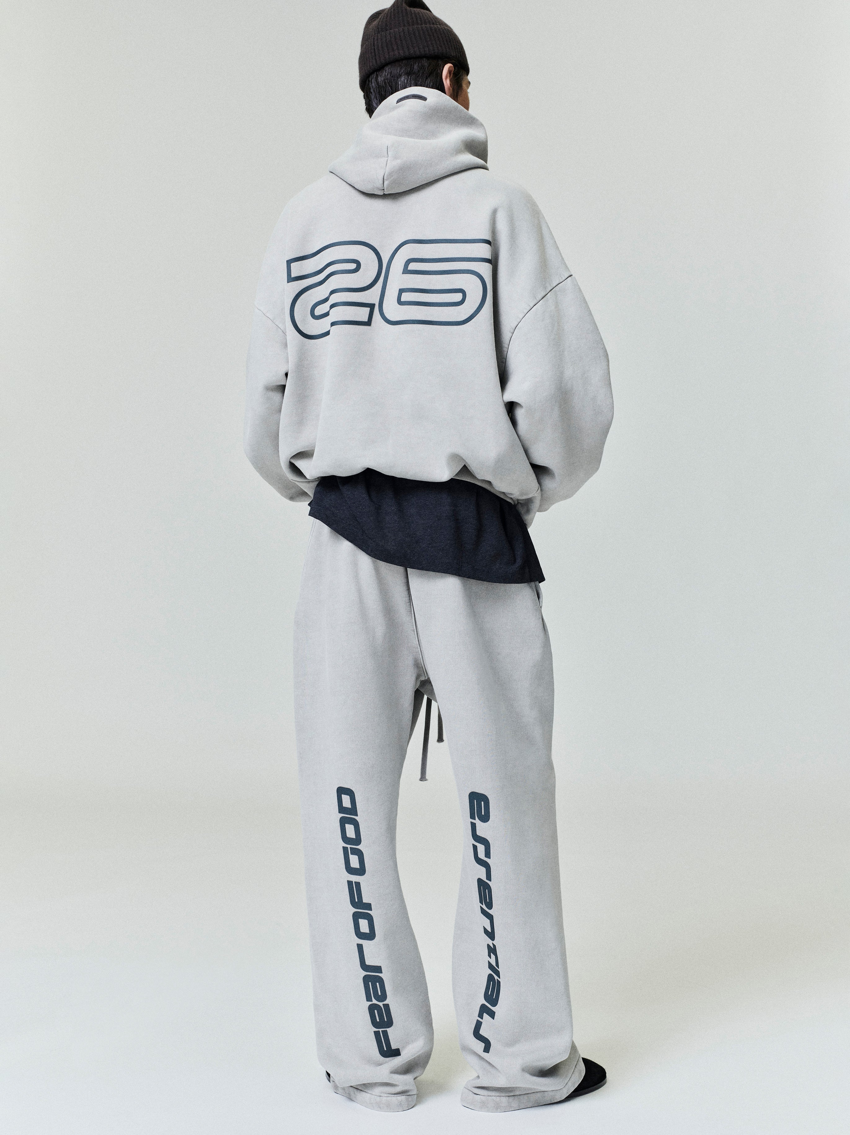 Rear view of light gray Heavy Fleece 90s Hoodie and matching pants with large outlined number 26 and vertical Fear of God text