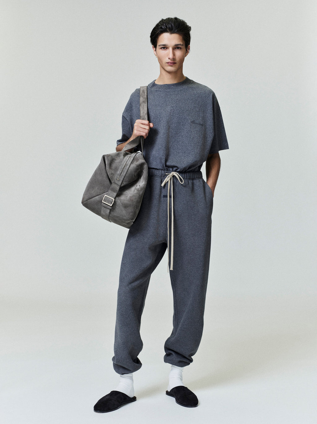 Dark gray classic sweatpants with elastic drawstring waistband and relaxed fit, paired with matching tee and casual slippers