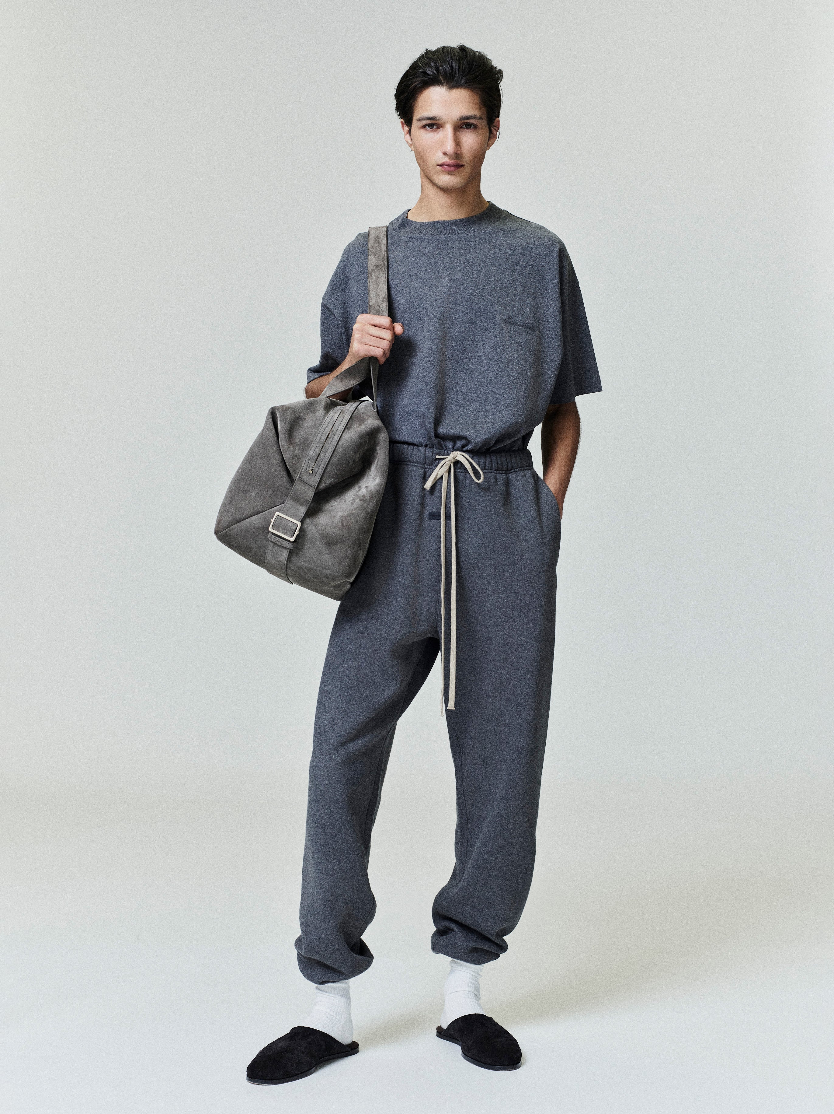 Dark gray classic sweatpants with elastic drawstring waistband and relaxed fit, paired with matching tee and casual slippers