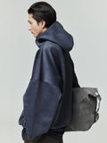 Profile of model wearing dark navy suede fleece modern hoodie with oversized fit and gray suede backpack 0011_HO25_F_L26_3202.jpg