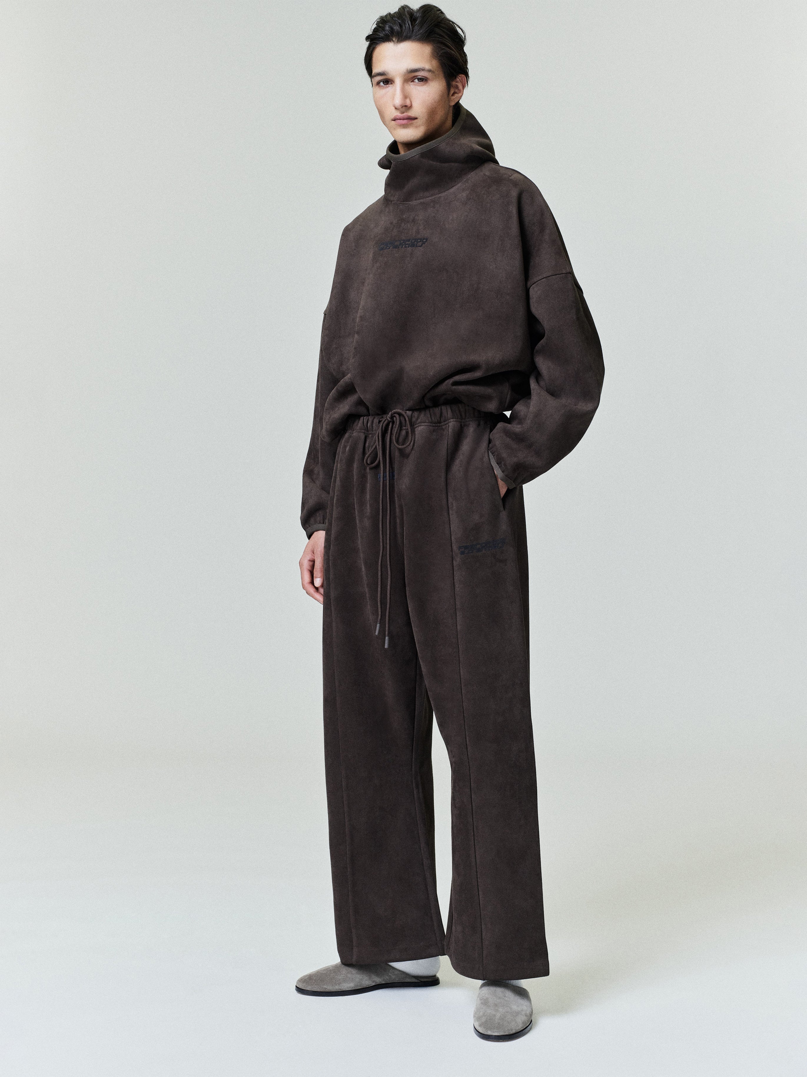Full-length view of model wearing dark brown suede fleece modern hoodie with relaxed fit and matching pants, file 0024_HO25_F_L17_2091.jpg