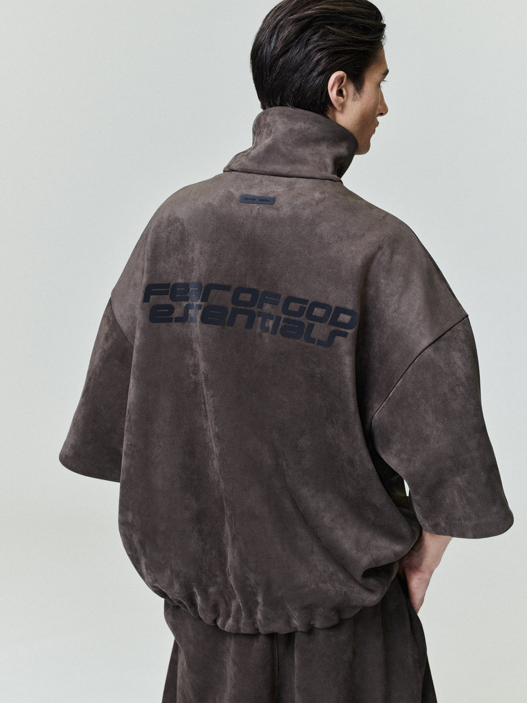 Rear view of model wearing suede fleece high neck jacket with wide 3/4 sleeves and printed back, file 0026_HO25_F_L15_1833_OnModelImage.jpg