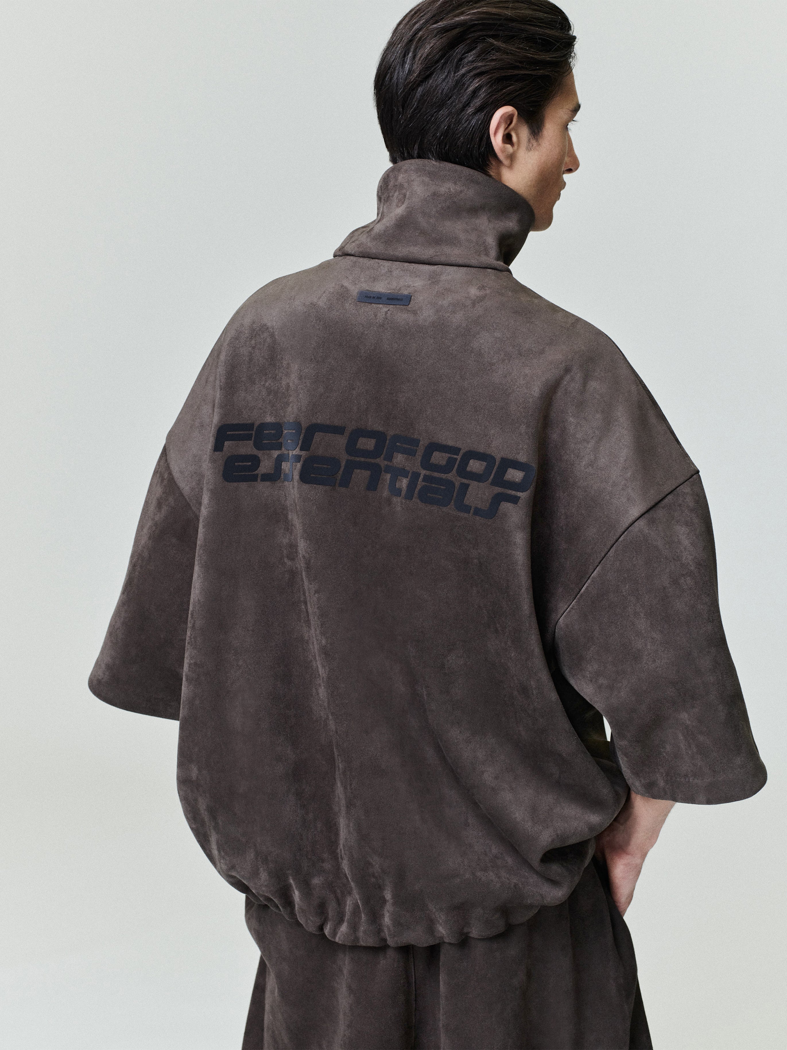 Rear view of model wearing suede fleece high neck jacket with wide 3/4 sleeves and printed back, file 0026_HO25_F_L15_1833_OnModelImage.jpg