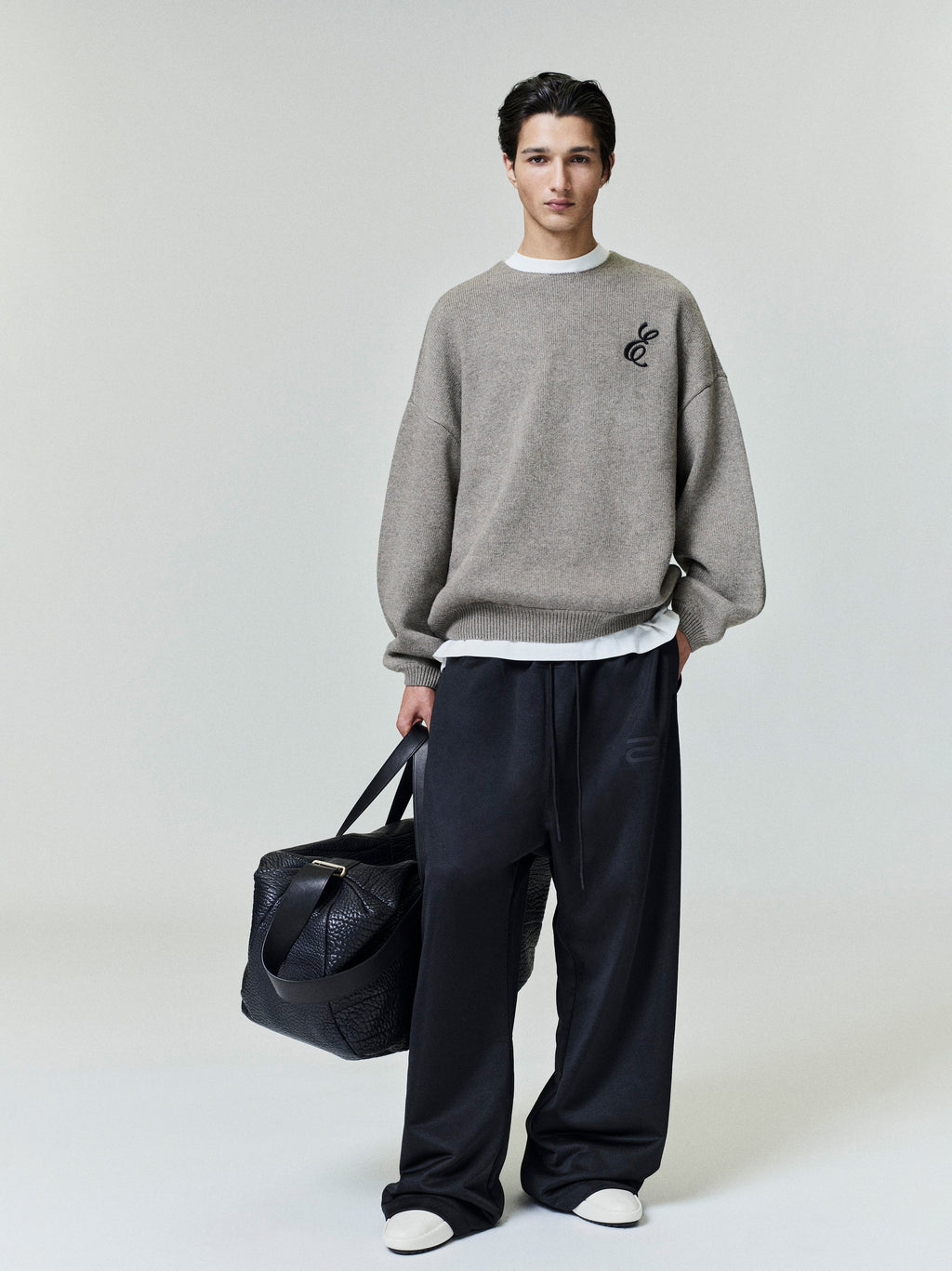 Model wearing black Satin Fleece Lounge Sweatpant with relaxed wide leg and subtle tonal logo detail, gallery position 0