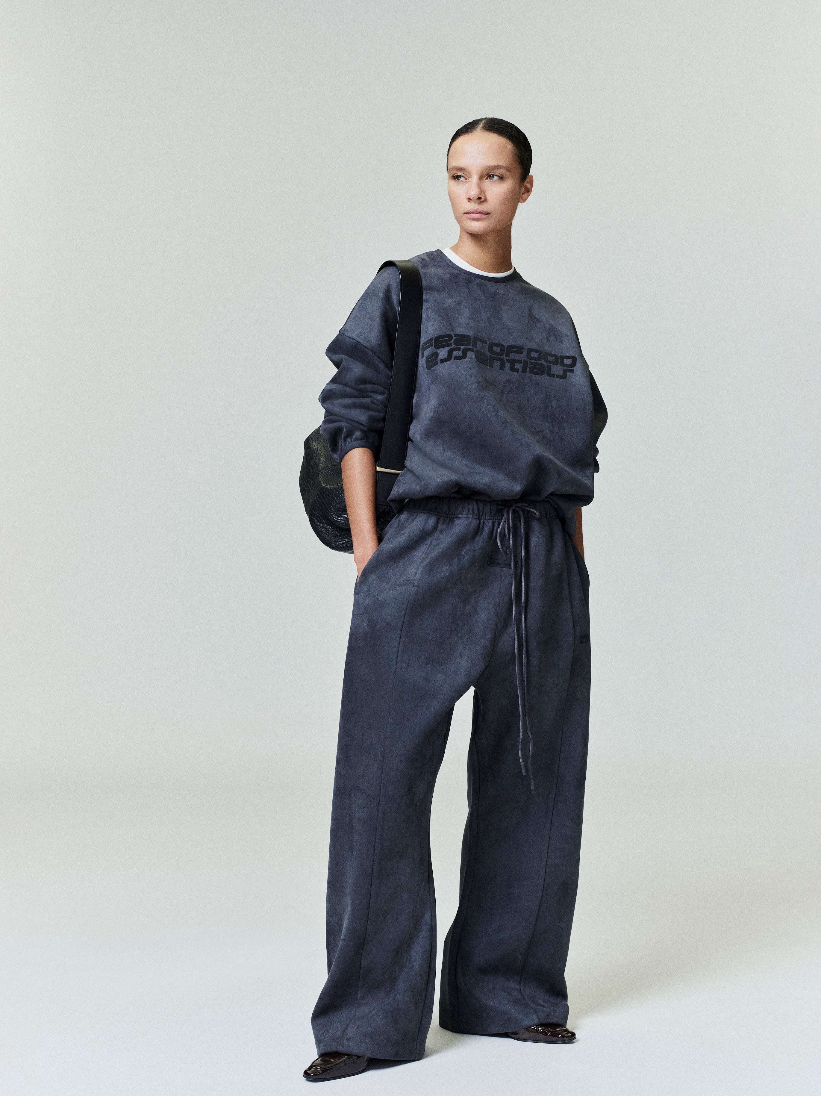 Model wearing dark charcoal Suede Fleece Modern Crewneck Sweatshirt with matching wide-leg pants in gallery shot 0043_HO25_FW_L37_0412.jpg