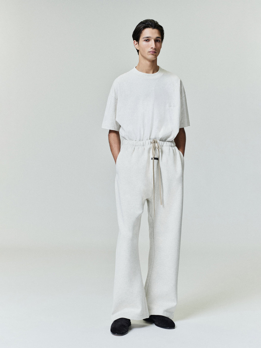 Male model in cream Flare Sweatpant with elastic waist and extended drawstrings, standing front view, gallery image 0