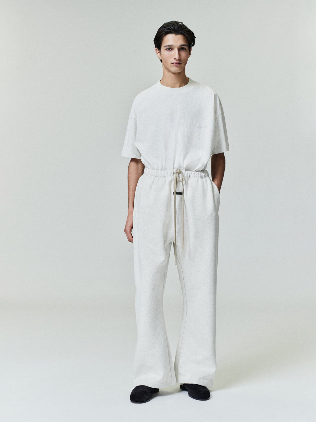 Male model wearing cream Flare Sweatpant with elastic waistband and long drawstrings, front view, gallery image 0