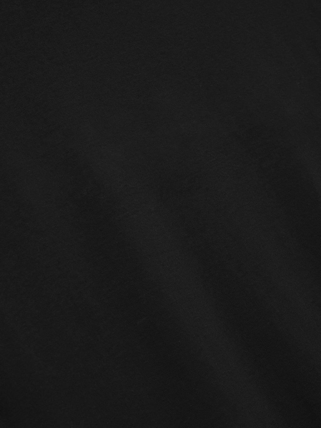 close-up of black medium-weight cotton jersey fabric with smooth texture and subtle drape