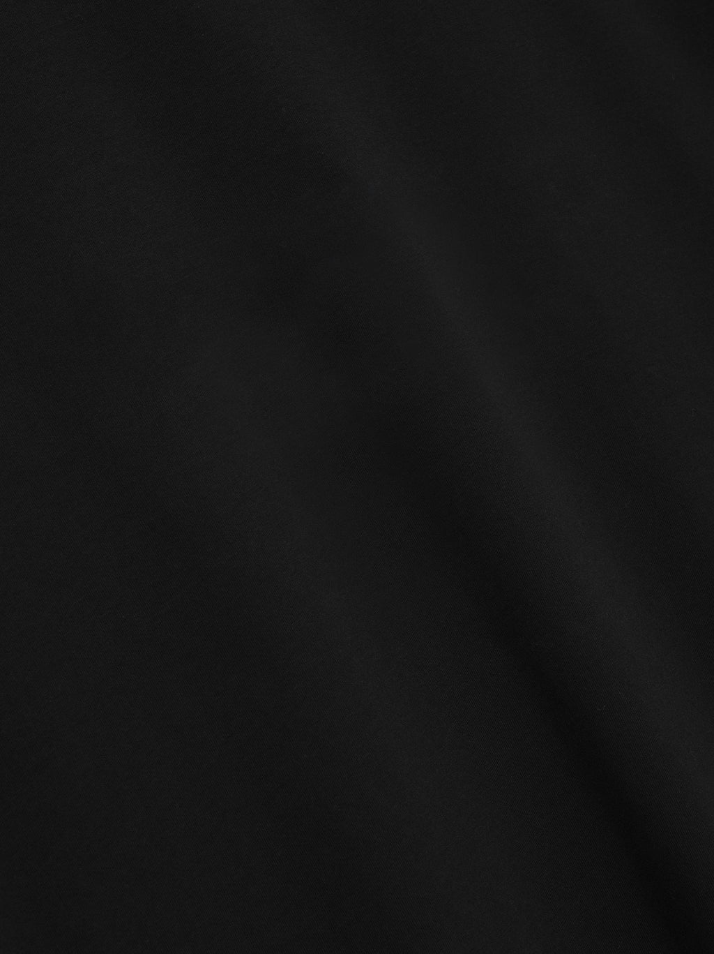 Close-up of smooth black fabric texture with subtle, soft folds and no visible patterns or logos