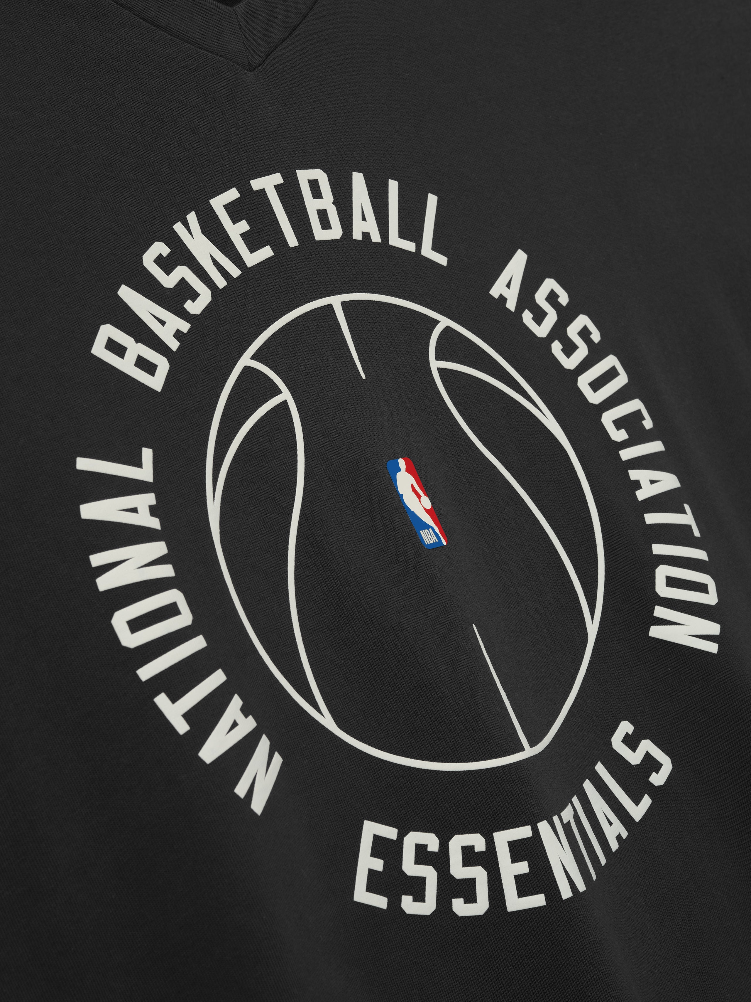 black oversized heavy cotton V-neck long sleeve tee with circular NBA Essentials basketball outline and logo center chest