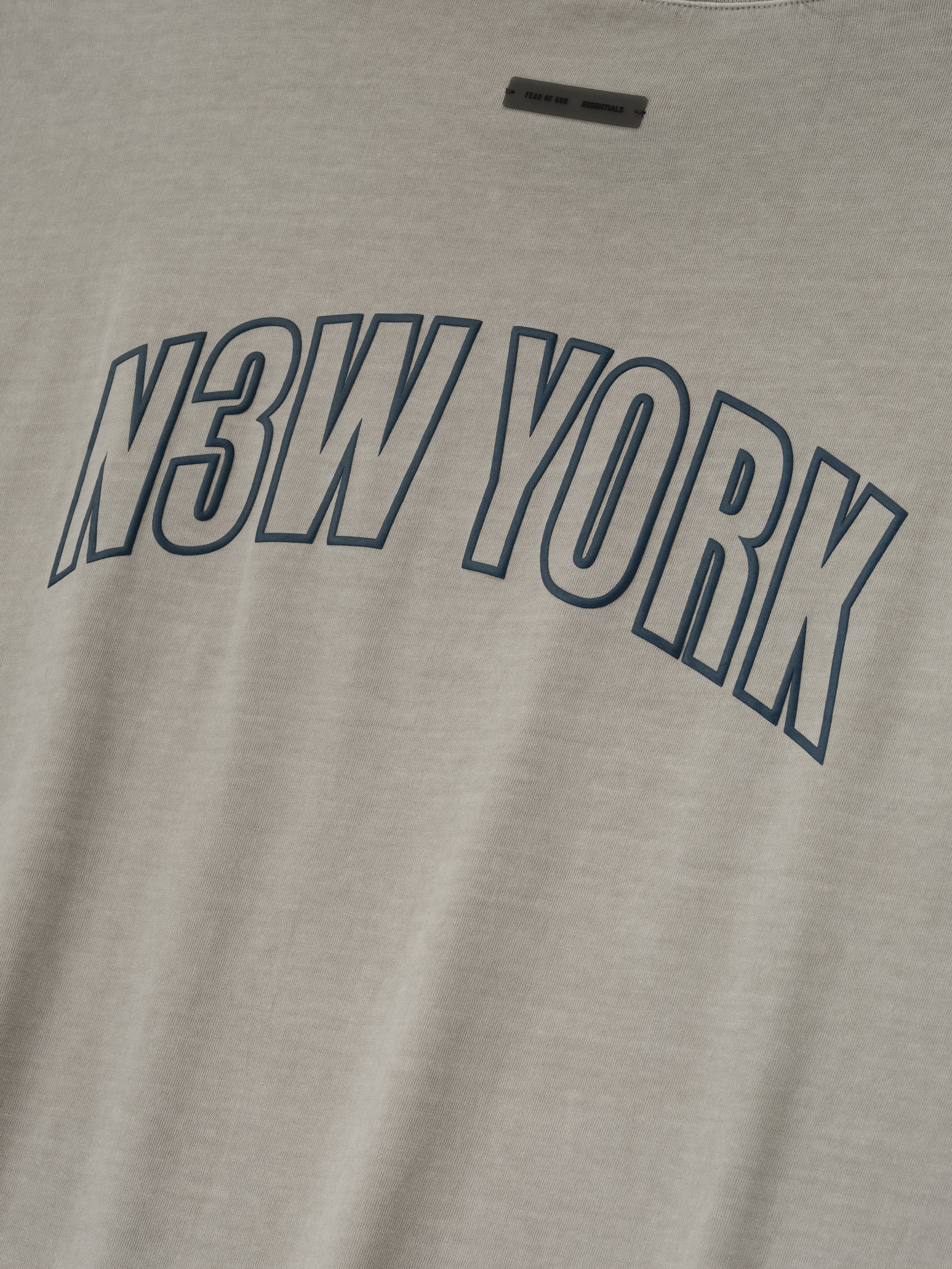 Close-up of smoke grey New York 90s Tee featuring bold navy N3W YORK print on soft cotton fabric
