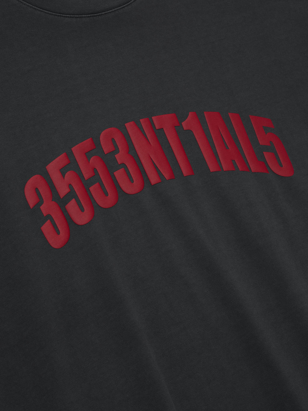 Close-up of iron grey Chicago 90s Tee with arched bold red alphanumeric print on smooth fabric surface
