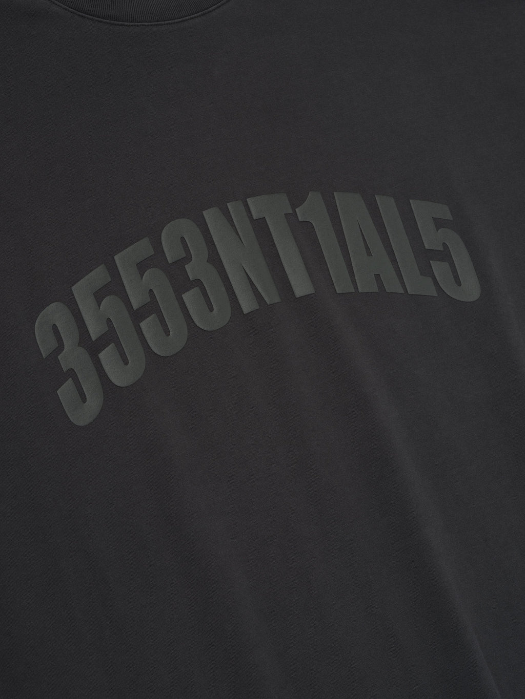 Close-up of vintage black Los Angeles 90s Tee with arched embossed alphanumeric print on soft fabric surface