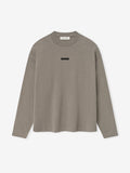 front view of taupe medium-weight cotton long sleeve tee with rib-knit crewneck and small rectangular chest logo patch