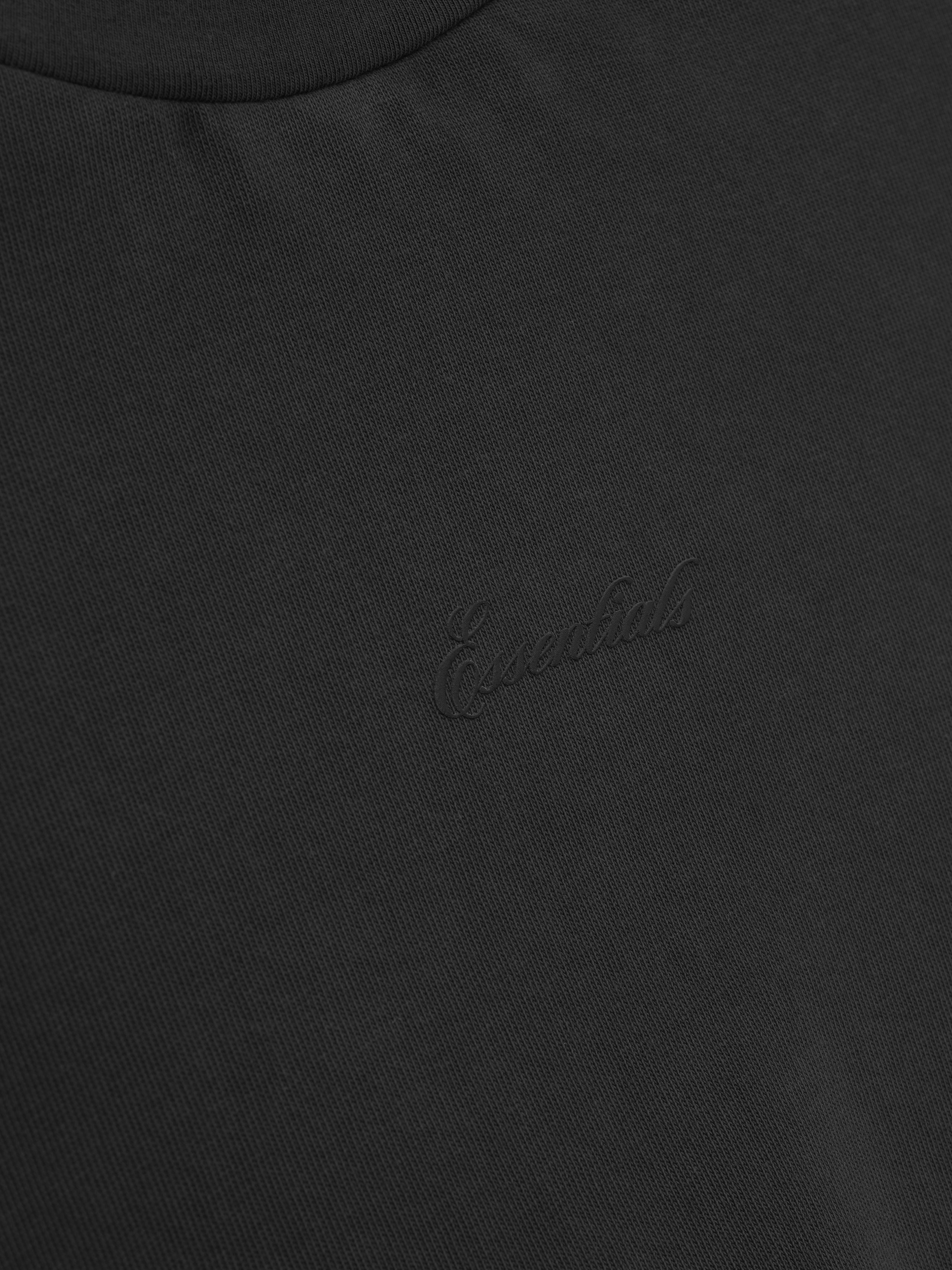 close-up of black heavyweight cotton jersey with embroidered subtle Essentials signature logo on chest
