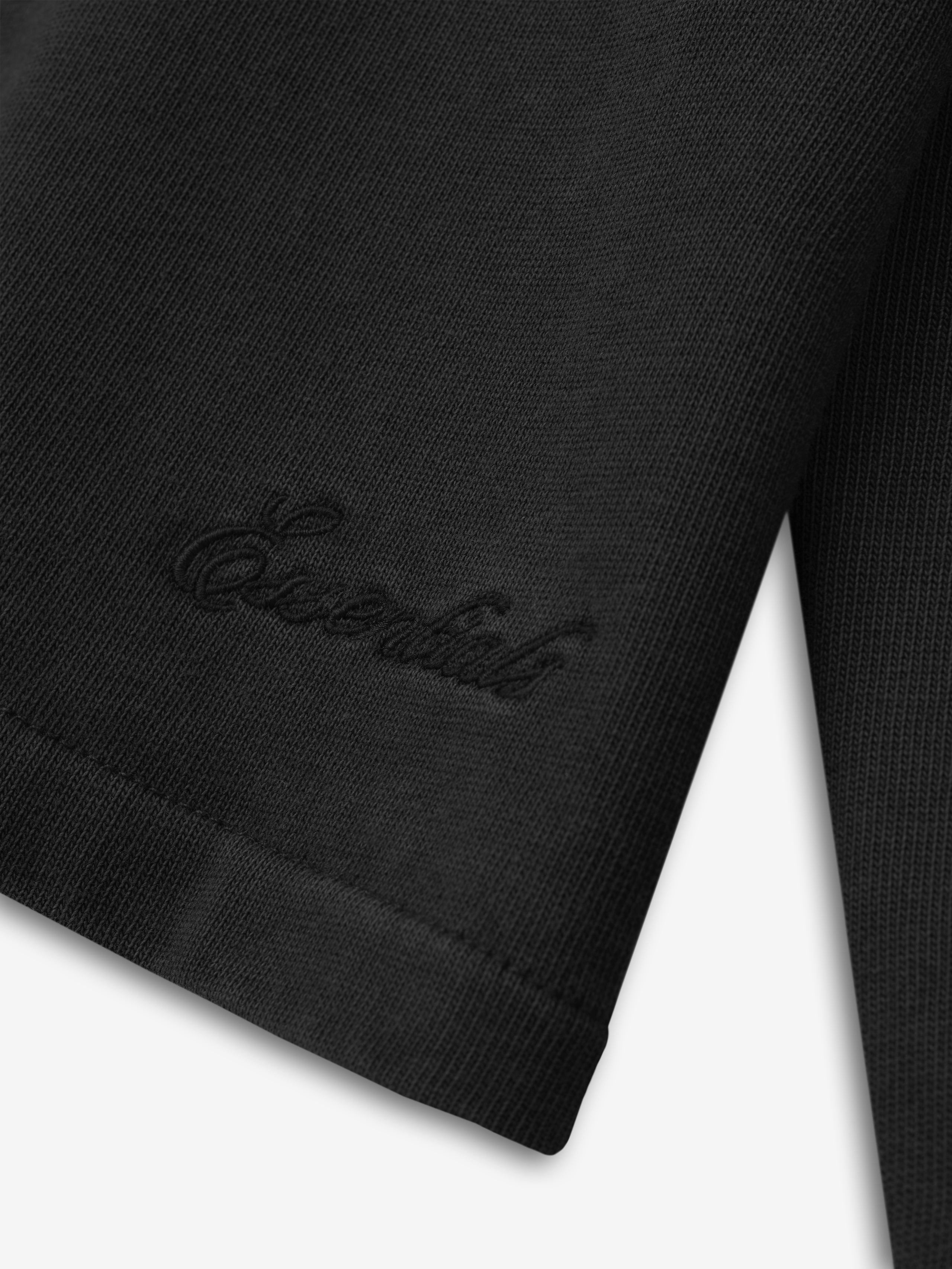 close-up of black heavyweight cotton jersey long sleeve tee cuff with subtle embossed script logo detail