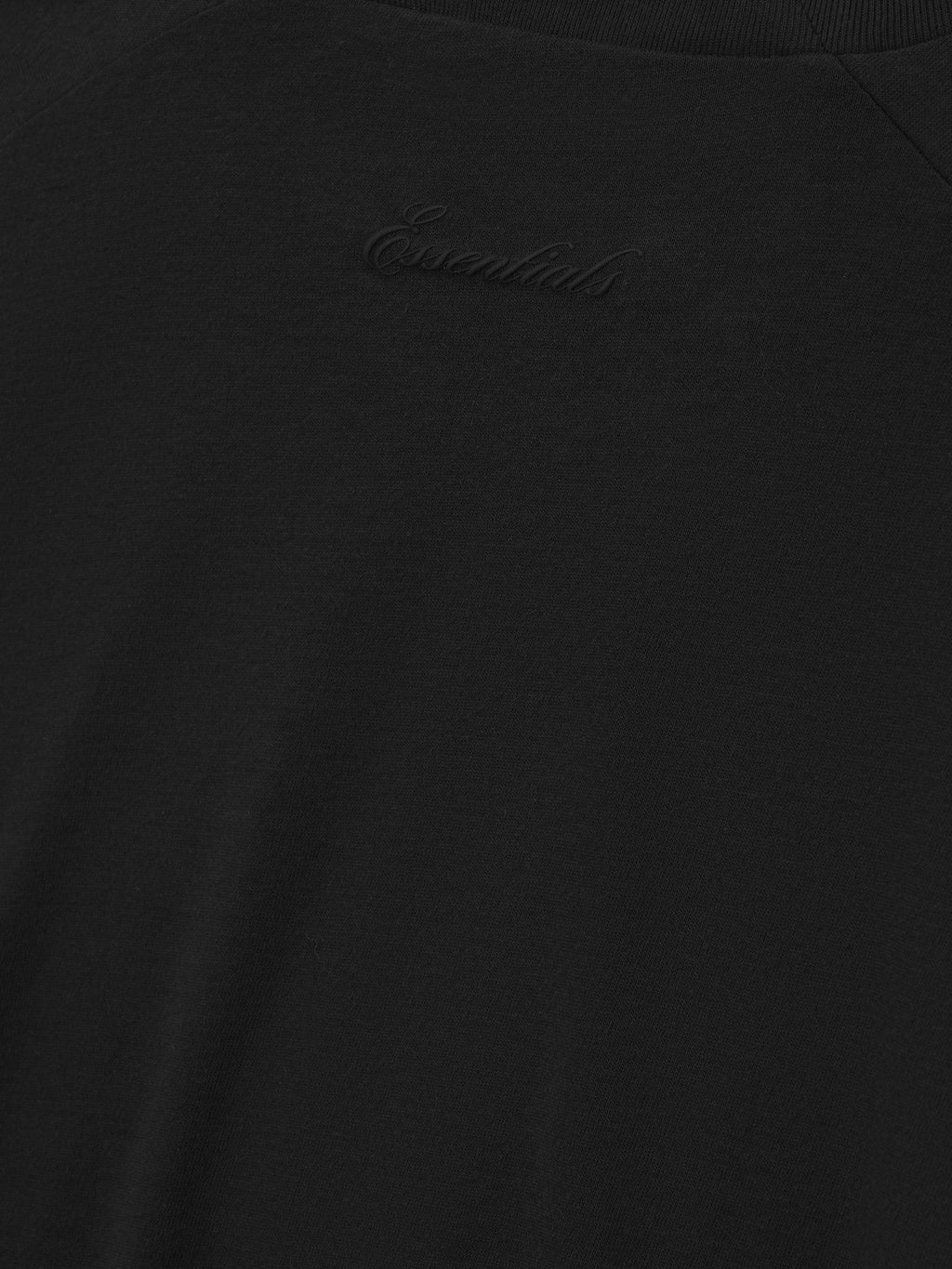 close-up of black cotton blend jersey tee with subtle tonal Essentials signature logo embroidered on chest