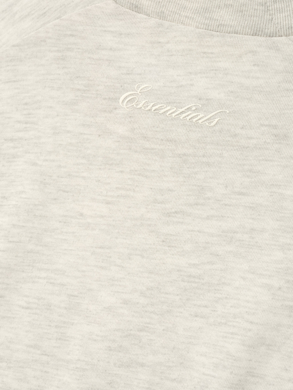 close-up of soft natural lightweight cotton blend jersey with tonal puff-print Essentials script logo on chest