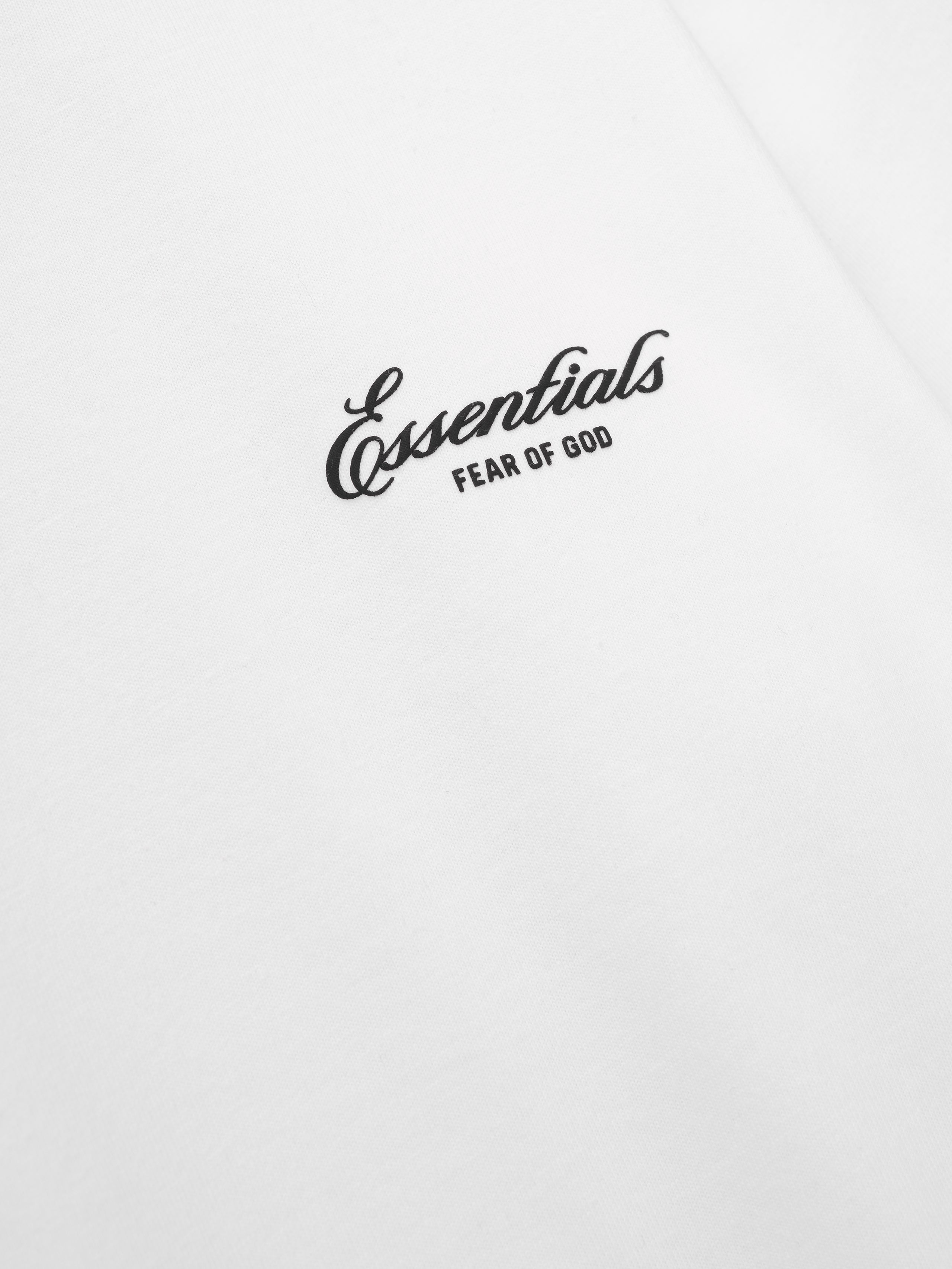 close-up of white cotton jersey fabric with black Essentials Fear of God puff-printed logo on women's tee