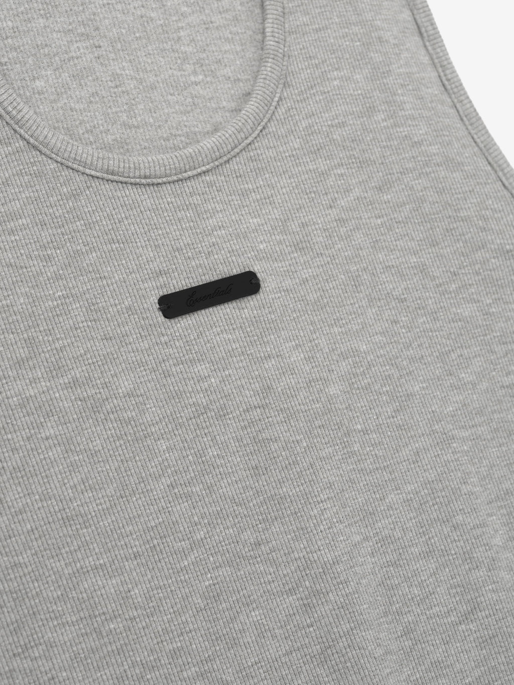 close-up of light gray ribbed cotton-rayon-spandex knit tank with U-neck and small black rectangular logo patch on chest