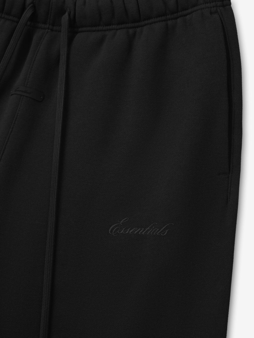 Black pants with 'essentials' script logo on a white background