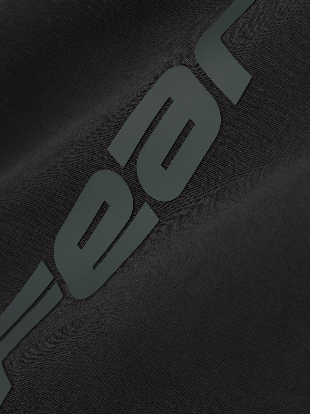 Close-up of vintage black Womens Heavy Fleece Flare Sweatpant fabric with large embossed logo detail