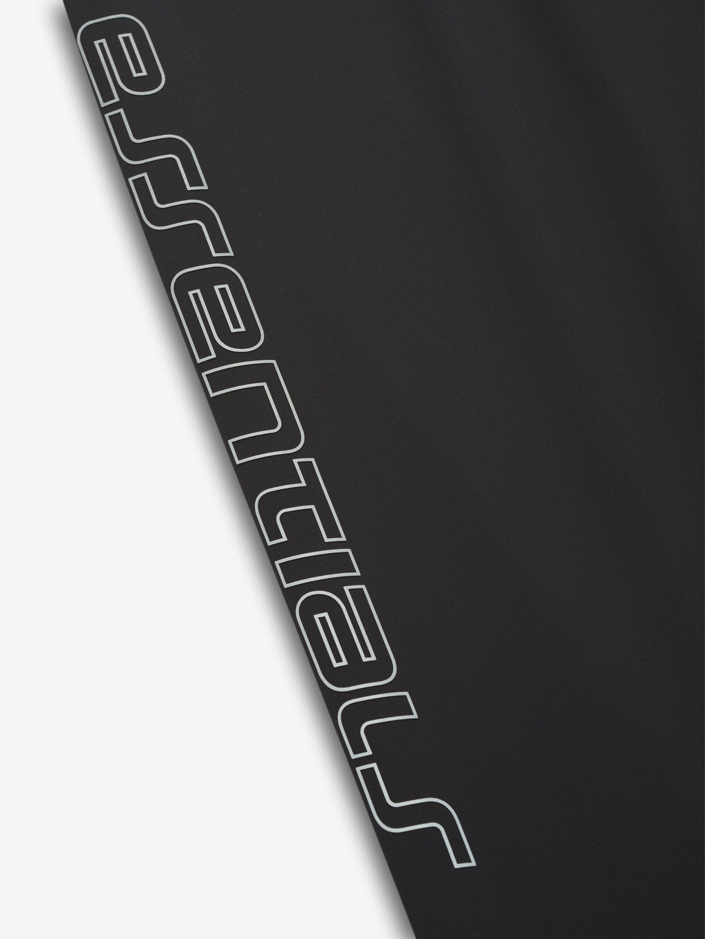Close-up of vintage black Tech Nylon Relaxed Track Pant leg highlighting bold vertical Essentials logo print detail