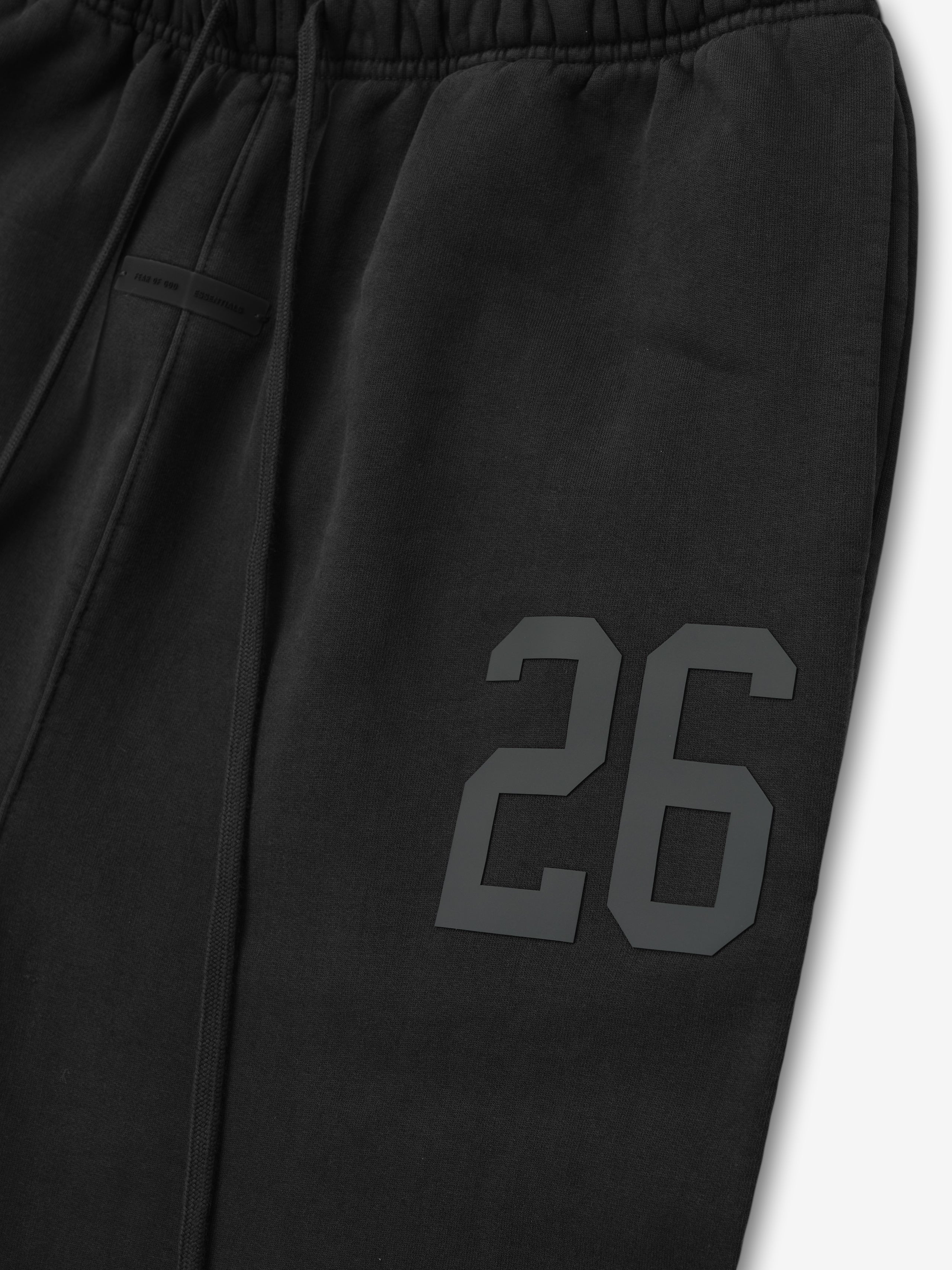 Close-up of vintage black heavy fleece sweatpant leg with embossed number 26 detail and elastic waistband