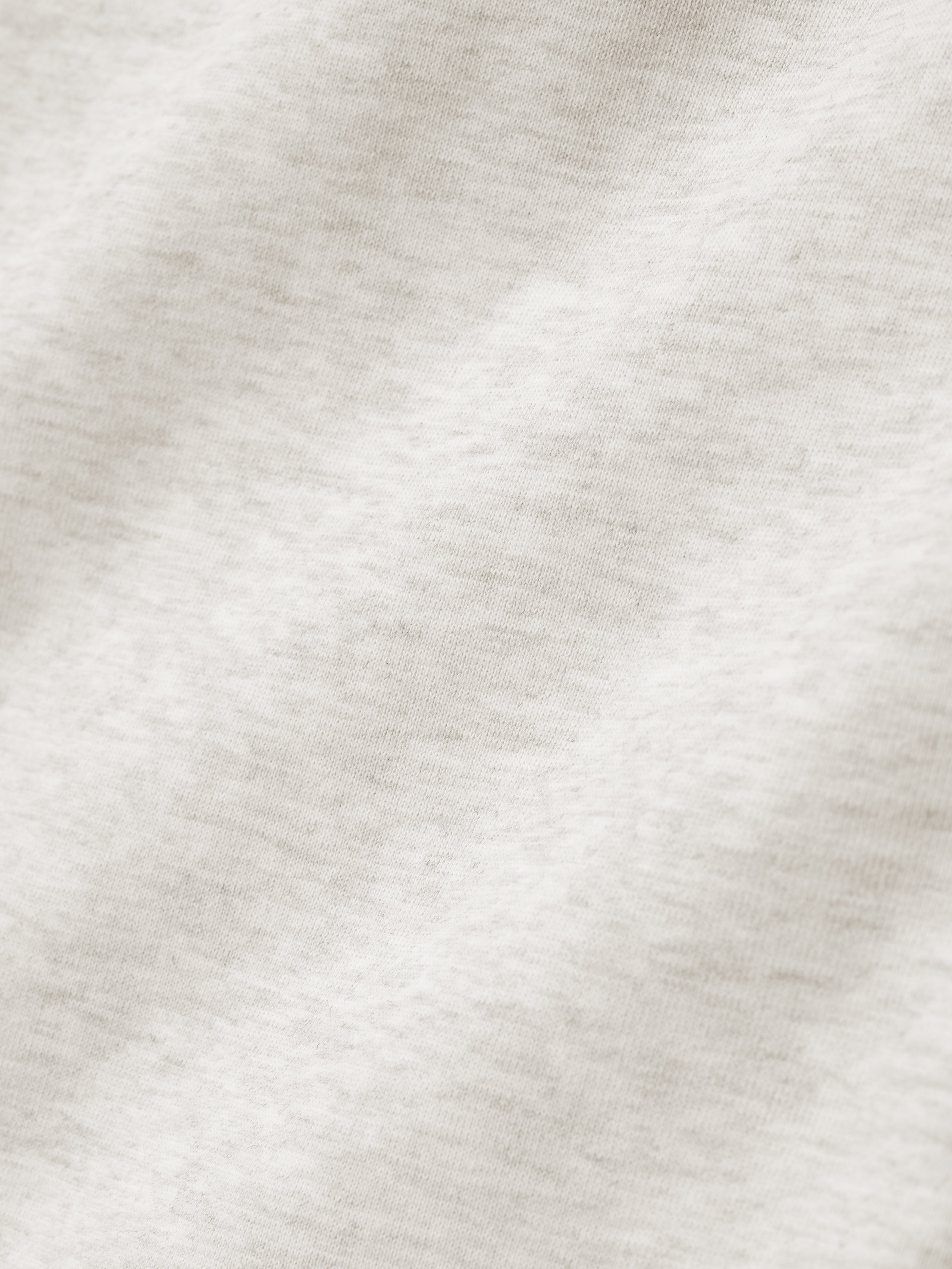 close-up of off-white heavyweight cotton fleece fabric showing soft texture and subtle knit detail