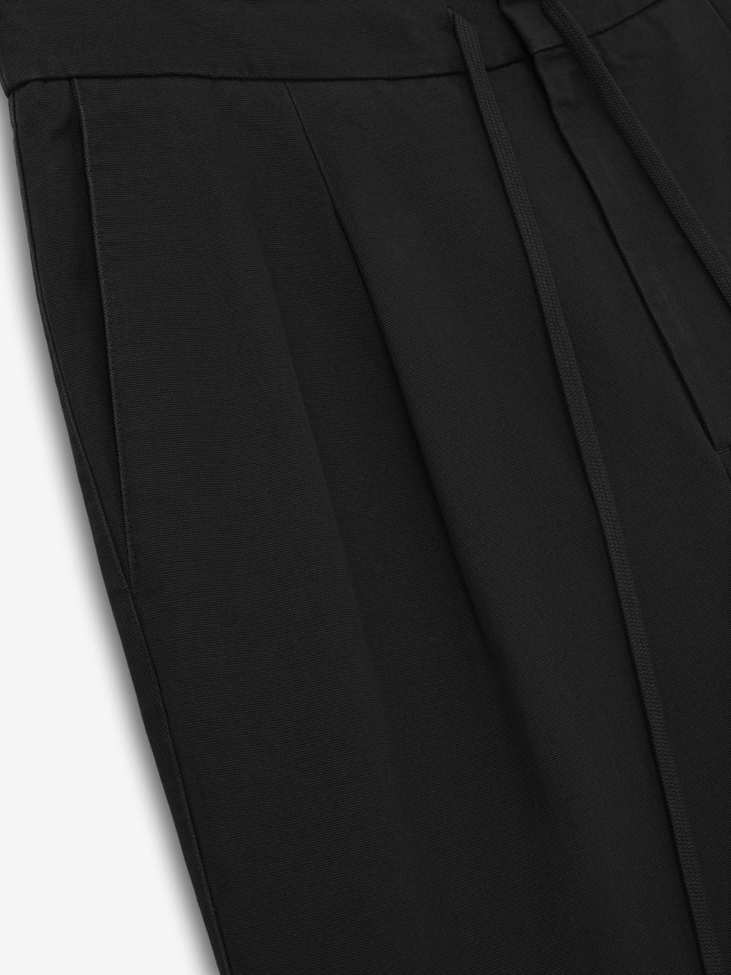 black cotton canvas pleat front pants with side pockets and encased elastic waistband with drawstring
