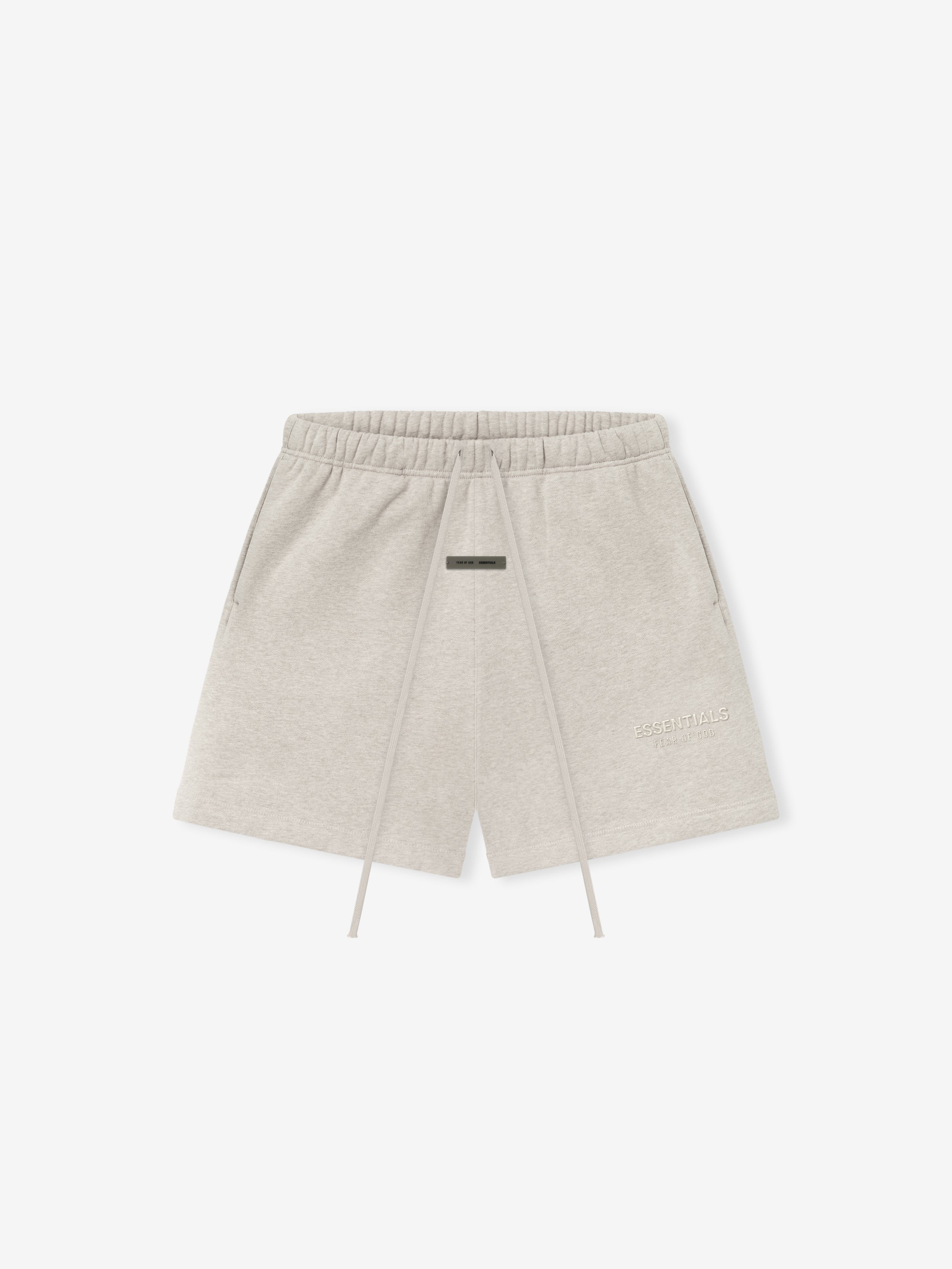 light beige core fleece sweatshort with elastic waist, long drawstrings, side pockets, and subtle Essentials logo on thigh