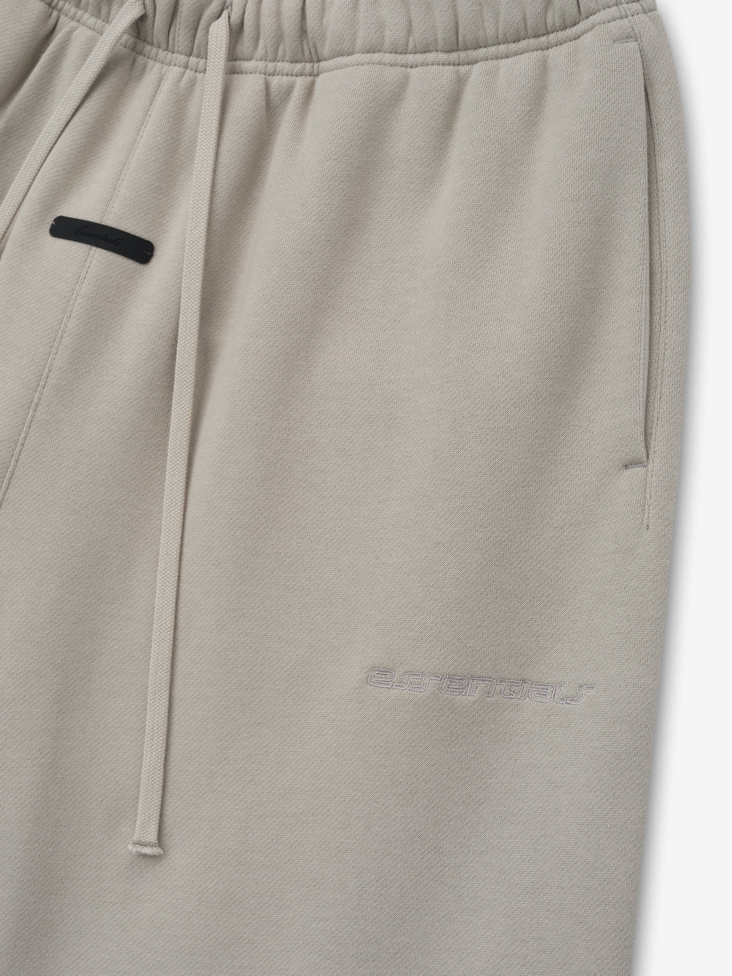 Grey sweatpants with a black patch on a white background