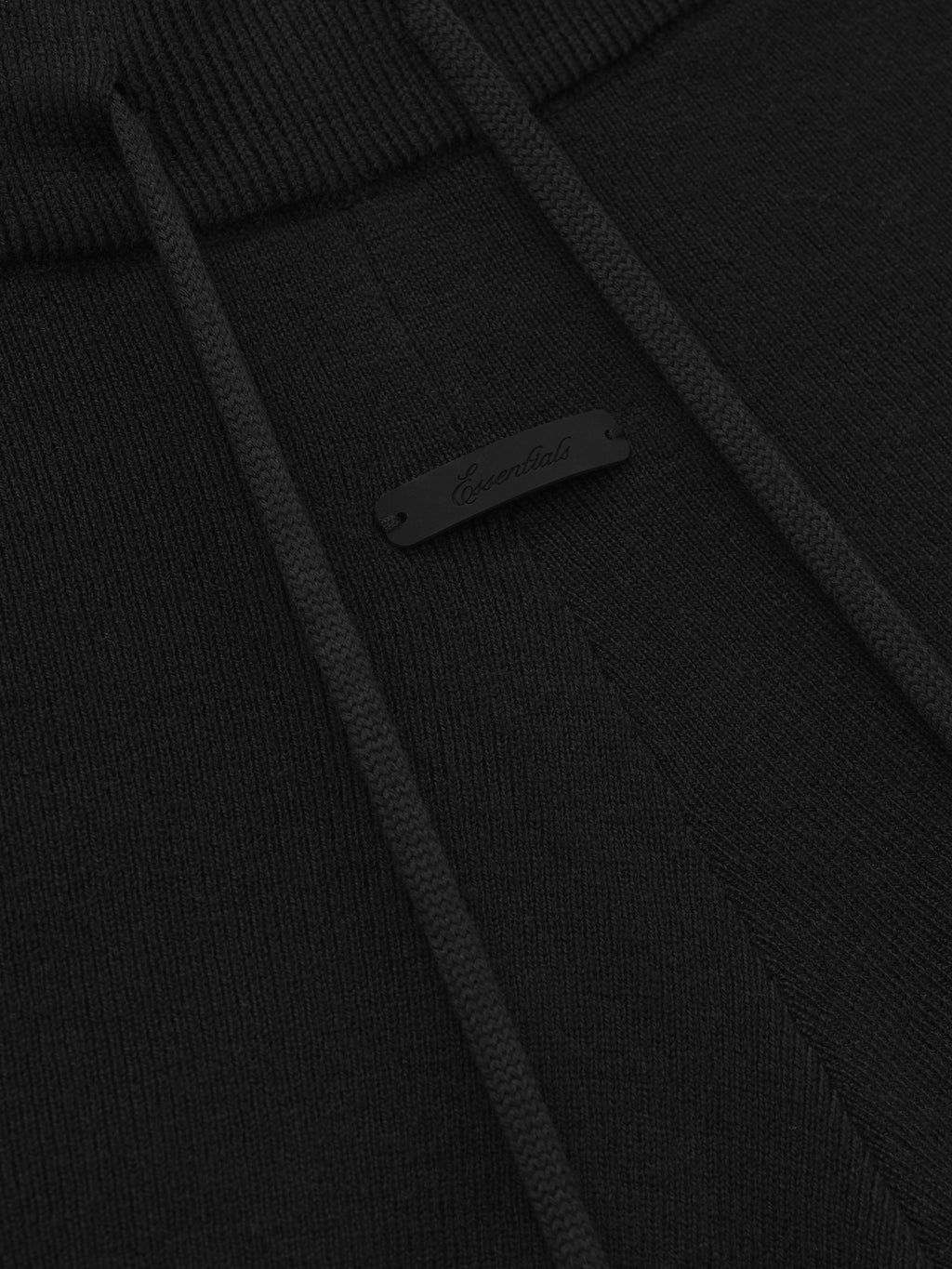 close-up of black rib knit fabric with drawstring and subtle branded tag detail on running shorts waistband