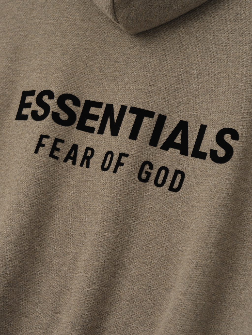 close-up of taupe fabric with black Essentials Fear of God logo printed on front of hoodie