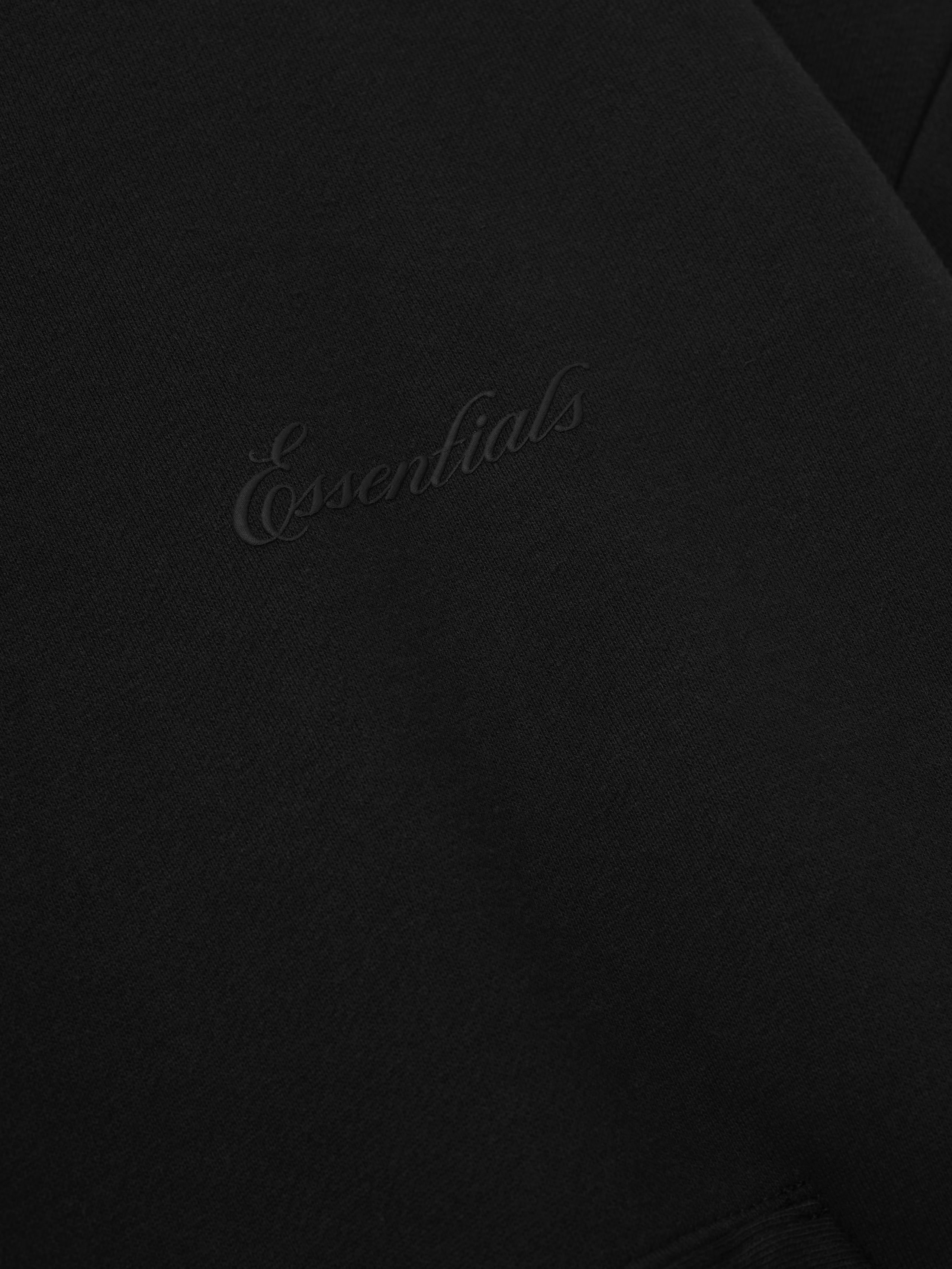 Black hoodie with 'Essentials' script logo