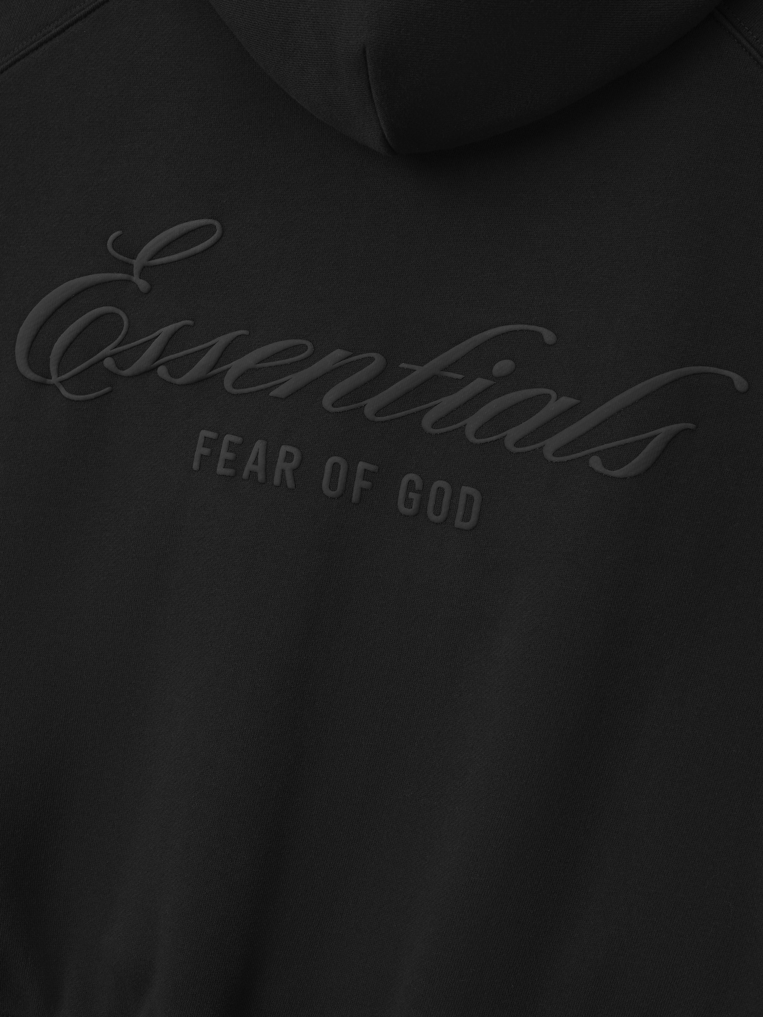 close-up of black heavyweight fleece hoodie showing embossed Essentials Fear of God logo on back panel