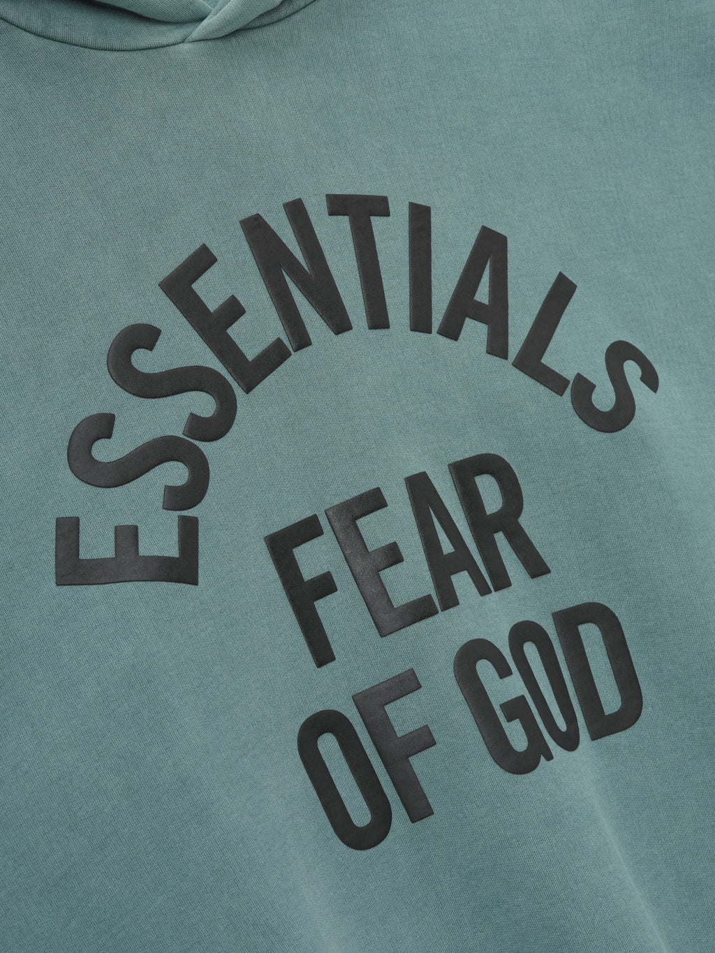 close-up of pigment-dyed green heavyweight fleece hoodie with large black Essentials Fear of God arched print on chest