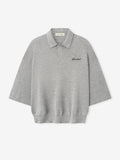 light grey heavy merino knit polo with relaxed fit, 3/4 sleeves, classic collar, and black Essentials signature embroidery on chest