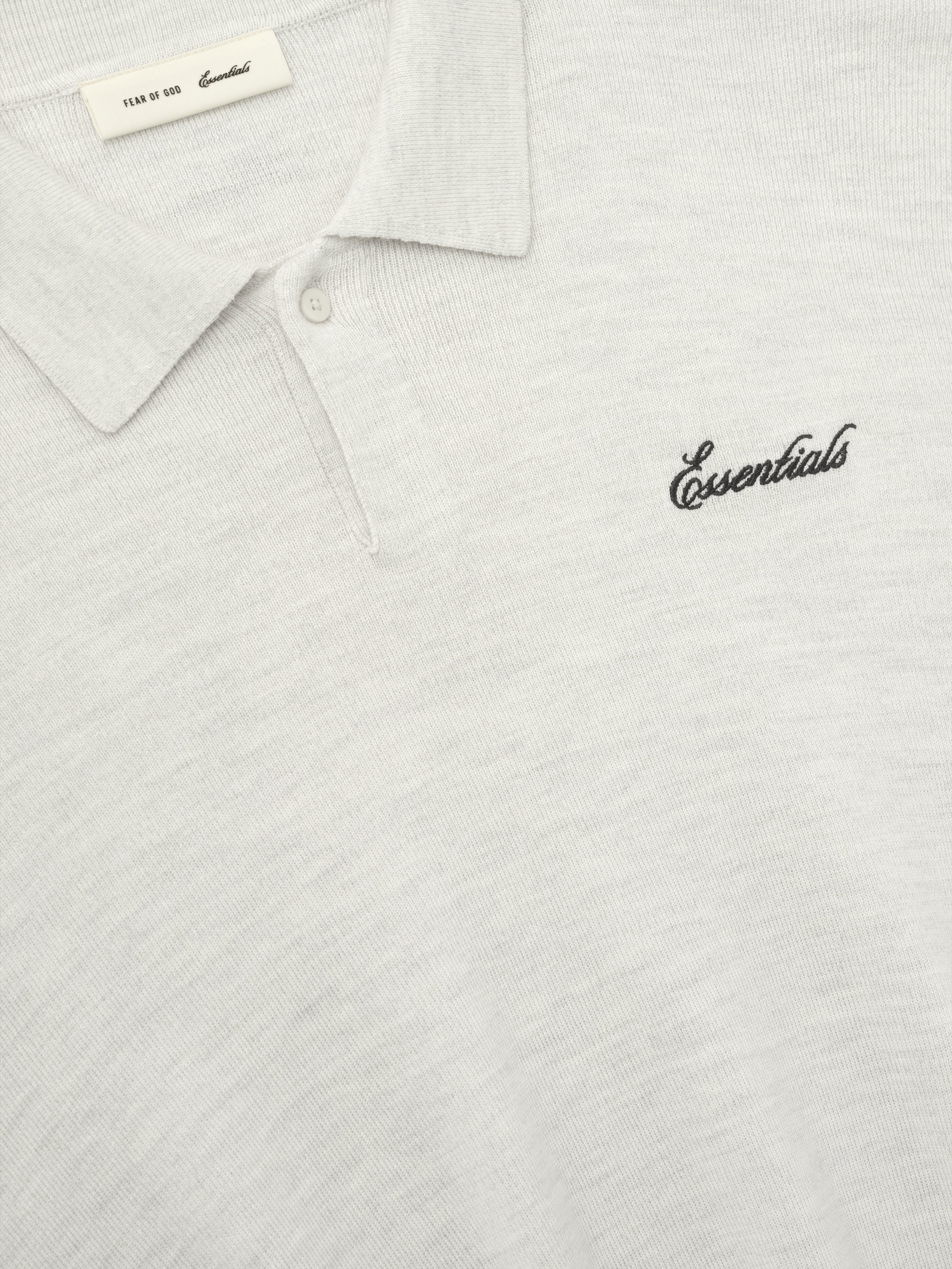 off-white heavy merino knit polo with classic collar and black Essentials script embroidery on chest