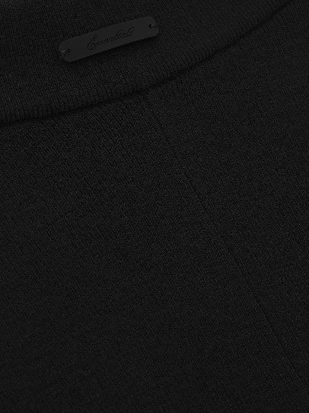 close-up of black rib knit fabric and small Essentials logo detail on waistband of women’s bike shorts