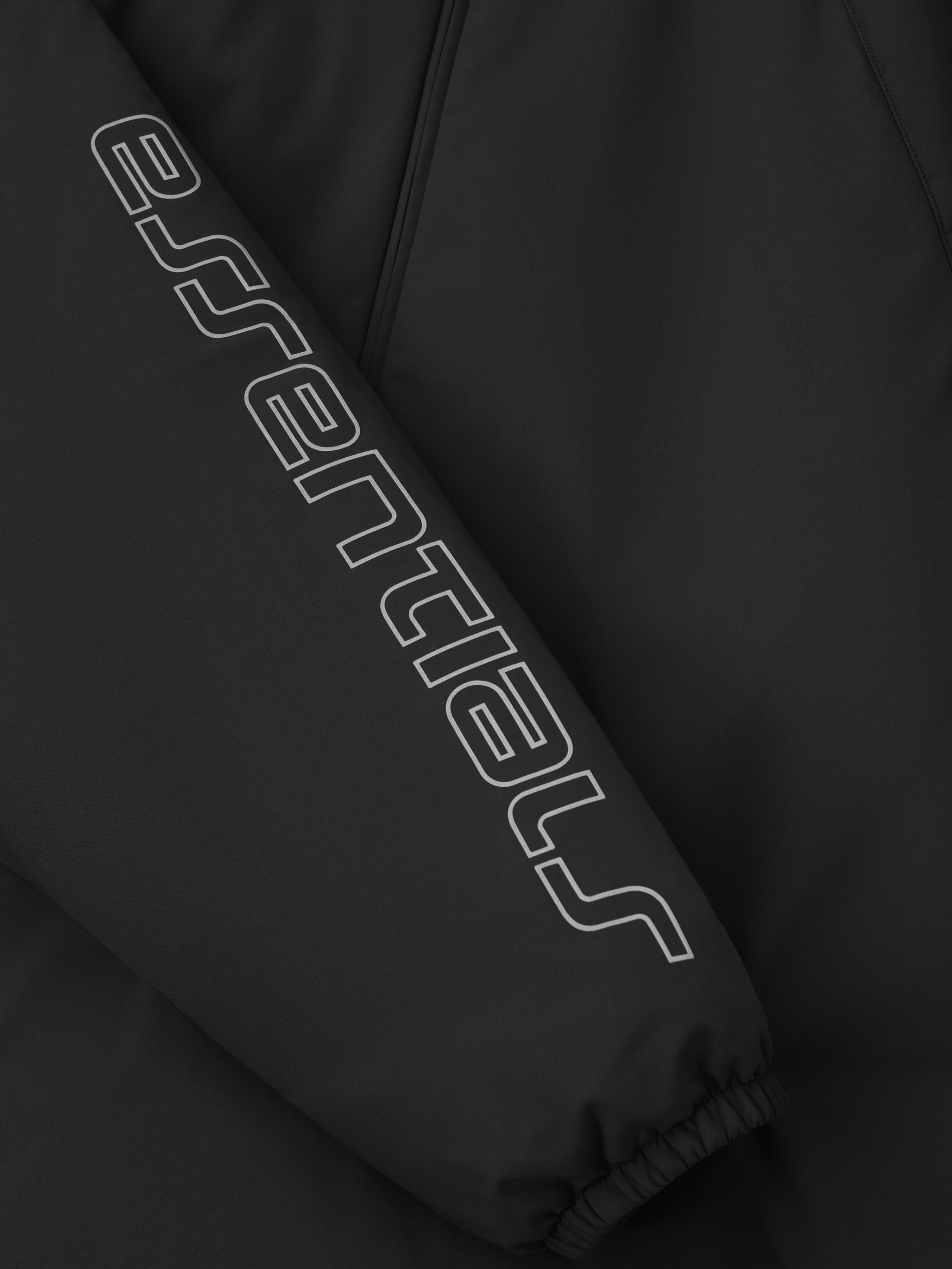 Close-up of vintage black Tech Nylon Half Zip Anorak sleeve featuring bold Essentials logo print and elastic cuff, gallery 0