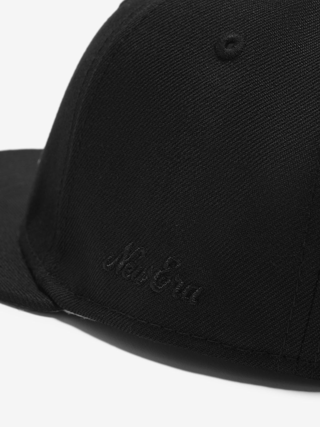 Black cap with 'New Era' logo on a white background
