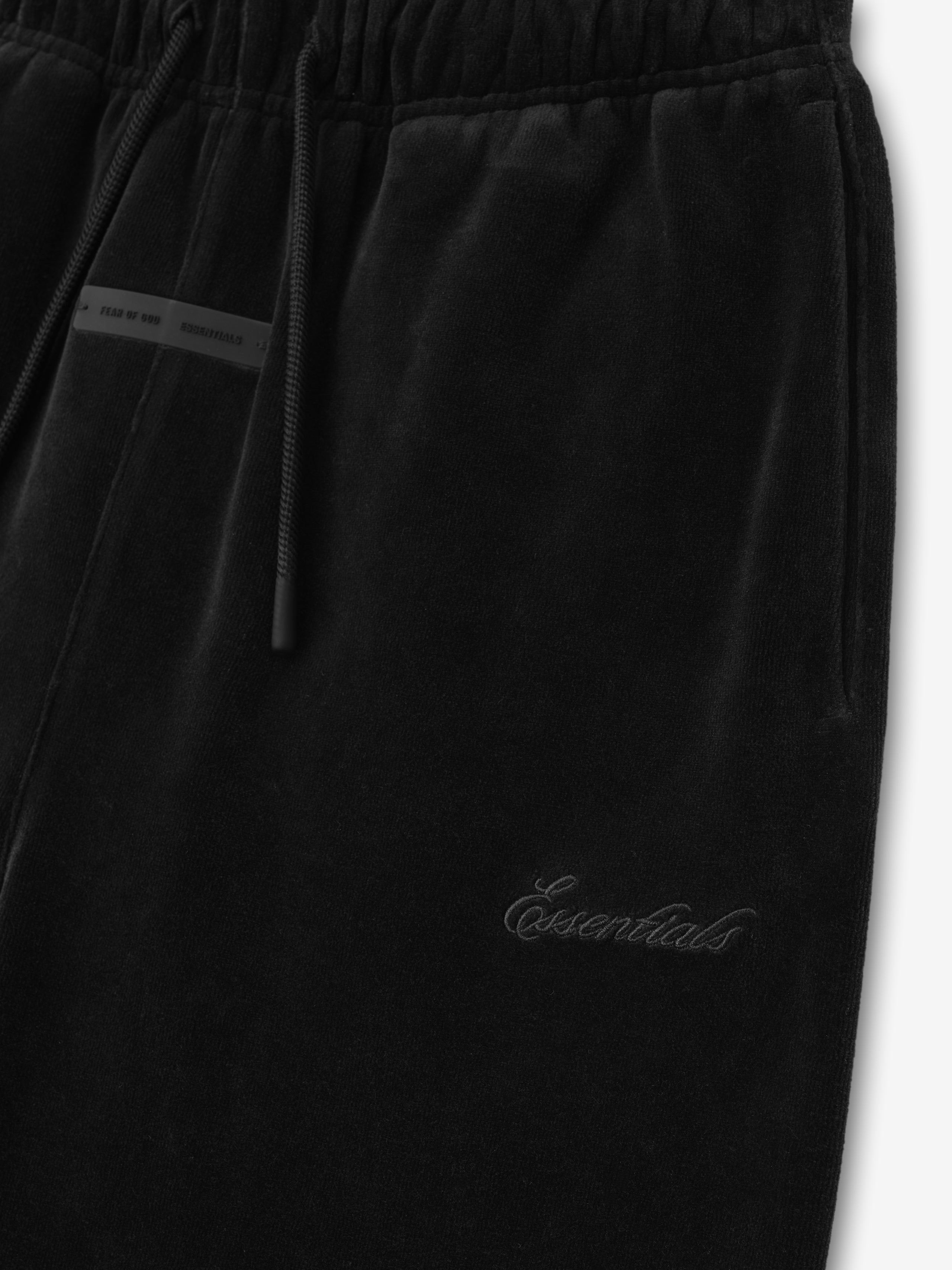Close-up of vintage black kids velour flare sweatpant showing elastic waistband, drawstring, side pocket, and tonal Essentials embroidery