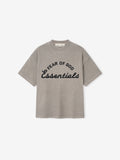 kids oversized vintage-style short sleeve tee in faded gray with bold Fear of God Essentials logo on front