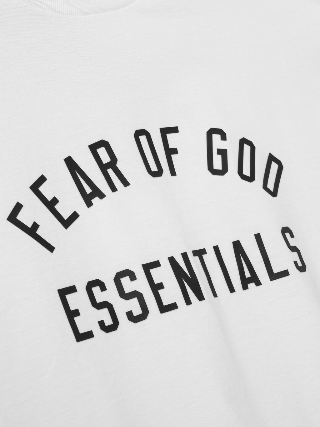 close-up of Fear of God Essentials chest logo printed in black on white cotton jersey fabric