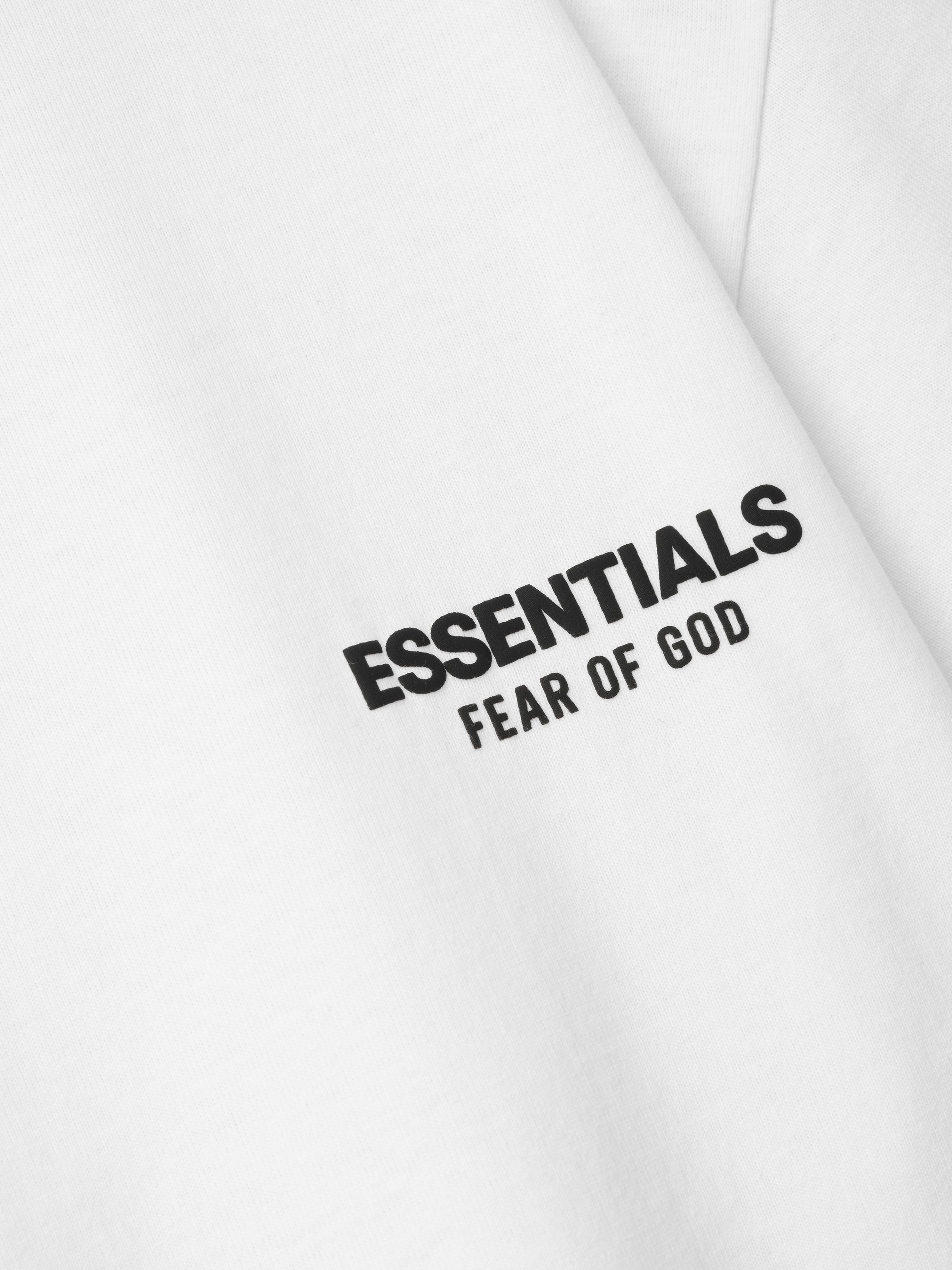 White sweatshirt with 'ESSENTIALS Fear of God' text on a white background