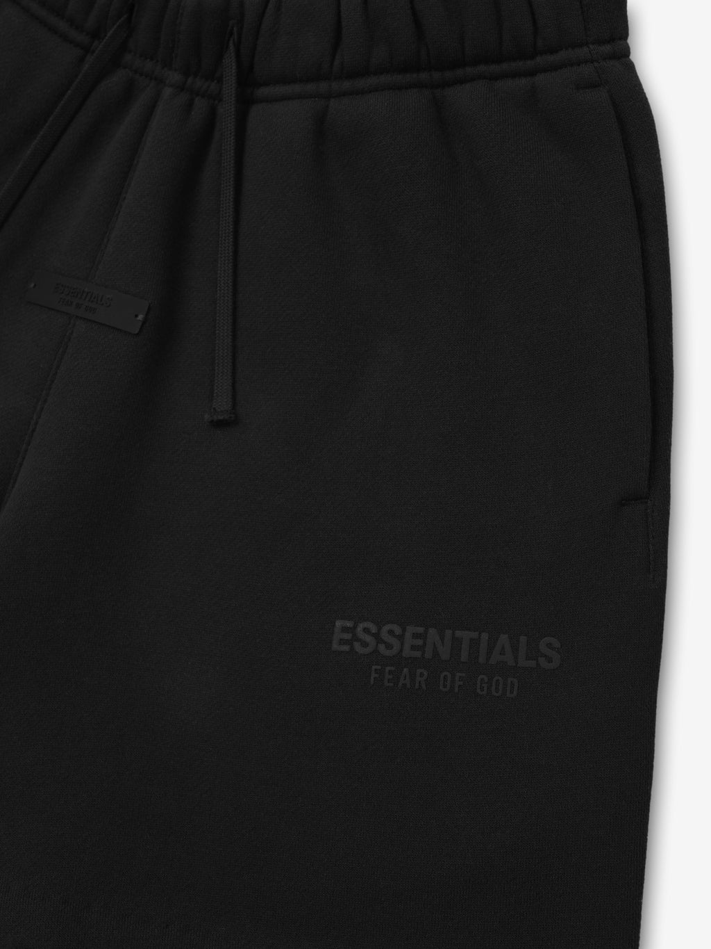 Black sweatpants with 'Essentials Fear of God' text on a white background