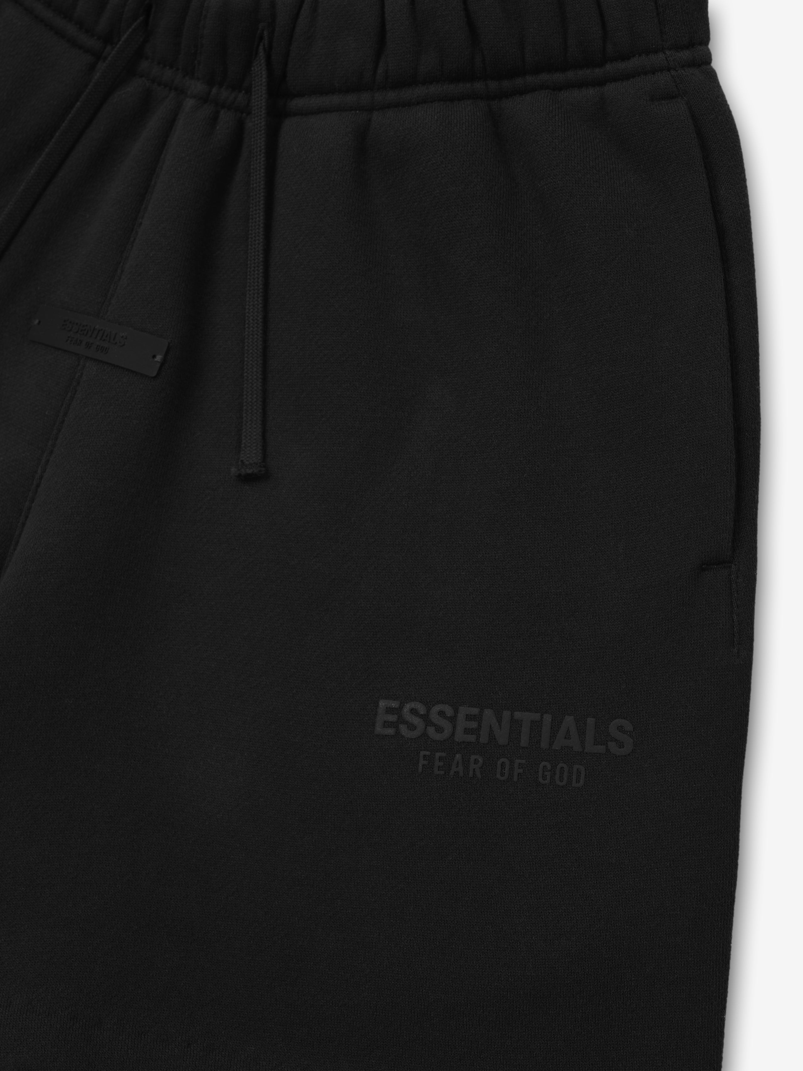 Black sweatpants with 'Essentials Fear of God' text on a white background