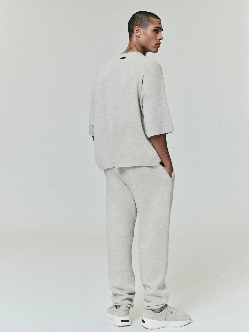 rear view of light gray vintage fleece sweatpant with slim fit leg and hands in pockets styling