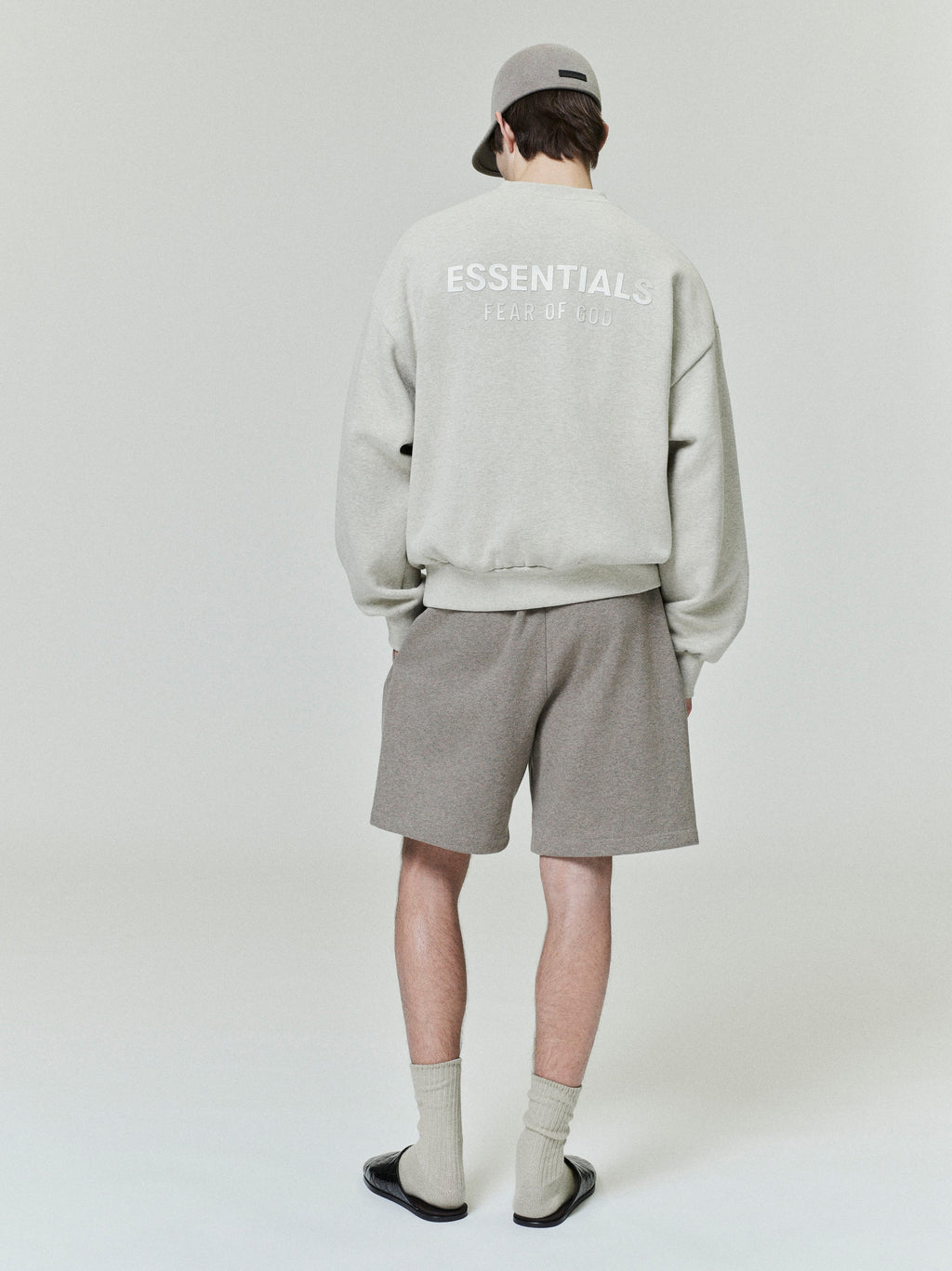 male model seen from behind wearing taupe classic fleece sweatshorts with relaxed fit and 90s-inspired mid-length leg